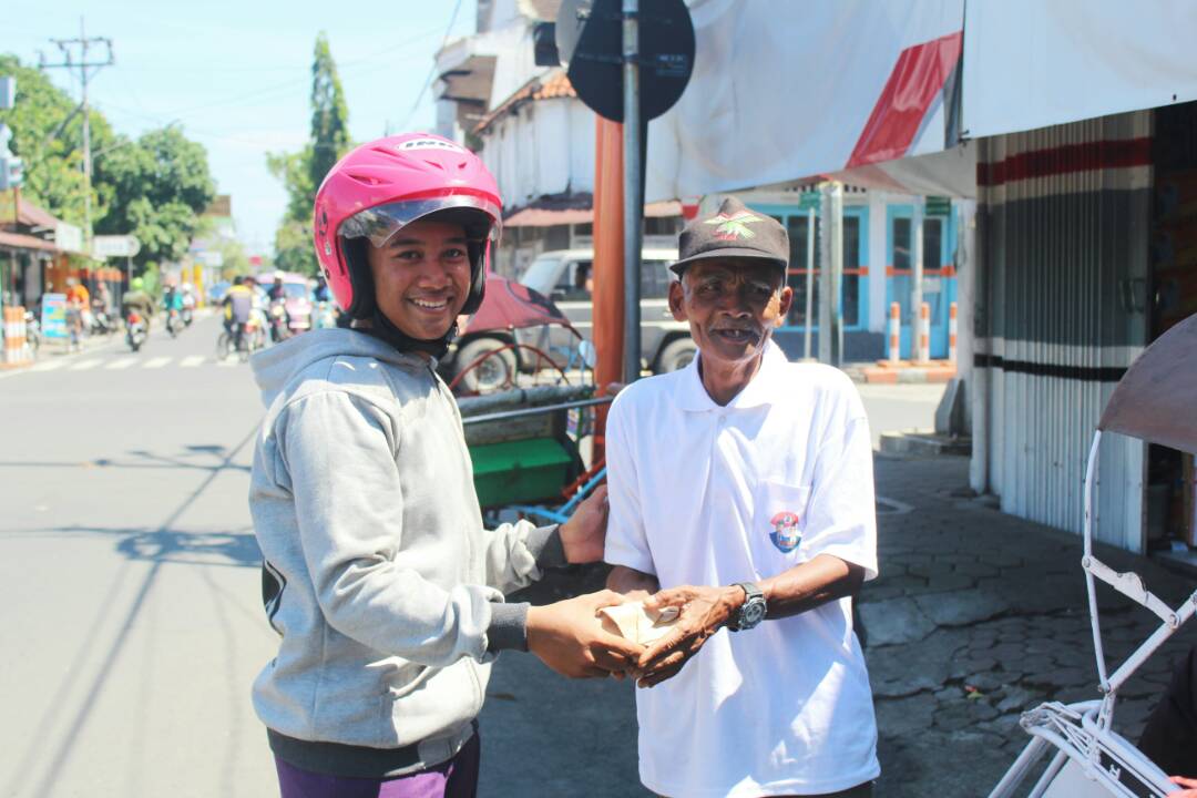 Salah satu siswa SMKN 1 Dlanggu memberikan nasi bungkus
